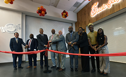 Ribbon cutting ceremony in front of Fuddruckers and Chick Fil A