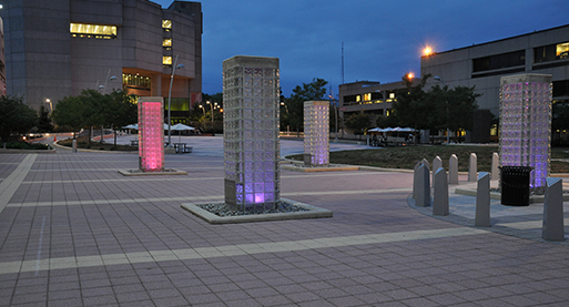 UDC courtyard at night with the pillars light in bright colors