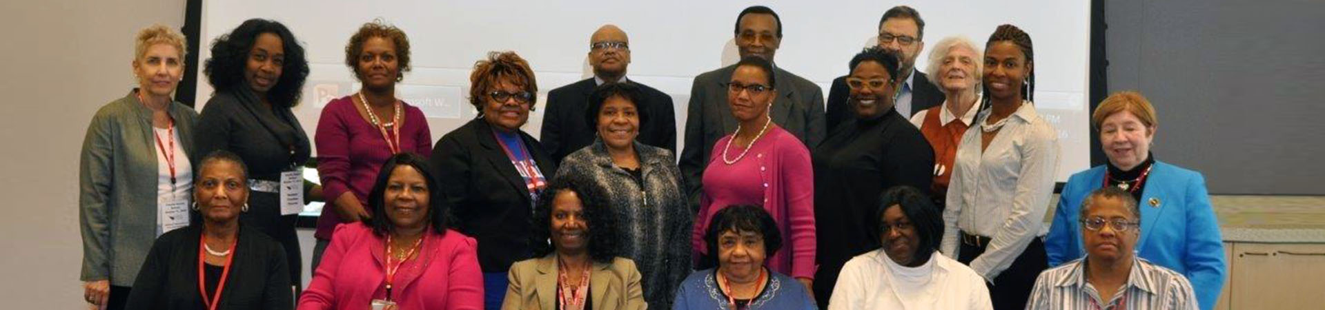 a group of faculty senate members standing in front of a wall posing