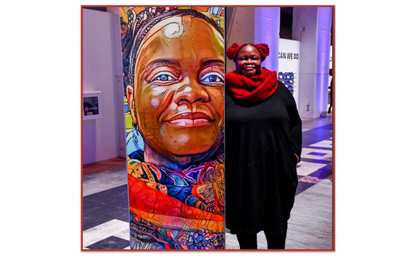 Dr. Nettrice R. Gaskins standing next to her own artwork