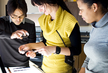 Three people looking at film negatives