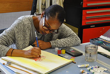 Young woman sketching a flower