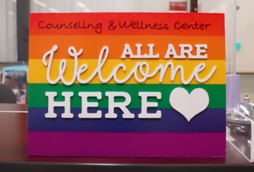 rainbow sign with All are welcome here written on it