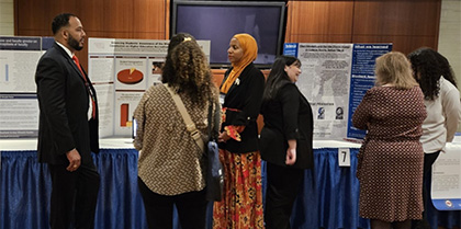 UDC students standing in front of presentation boards discussing the work