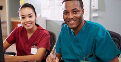 Two nurses collaborate at a computer