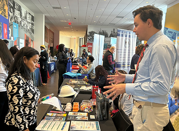 People talking with potential employeers at a career fair