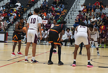 UDC men's basketball team playing a game.