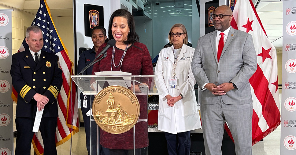 DC Mayor Muriel Bowser standing at a podium speaking