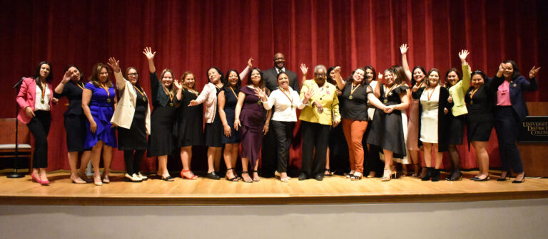 Graduates with Community College Dean Dr. Marilyn Hamilton (front row, in yellow) and Dr. Scott King, professor of hospitality (back row).