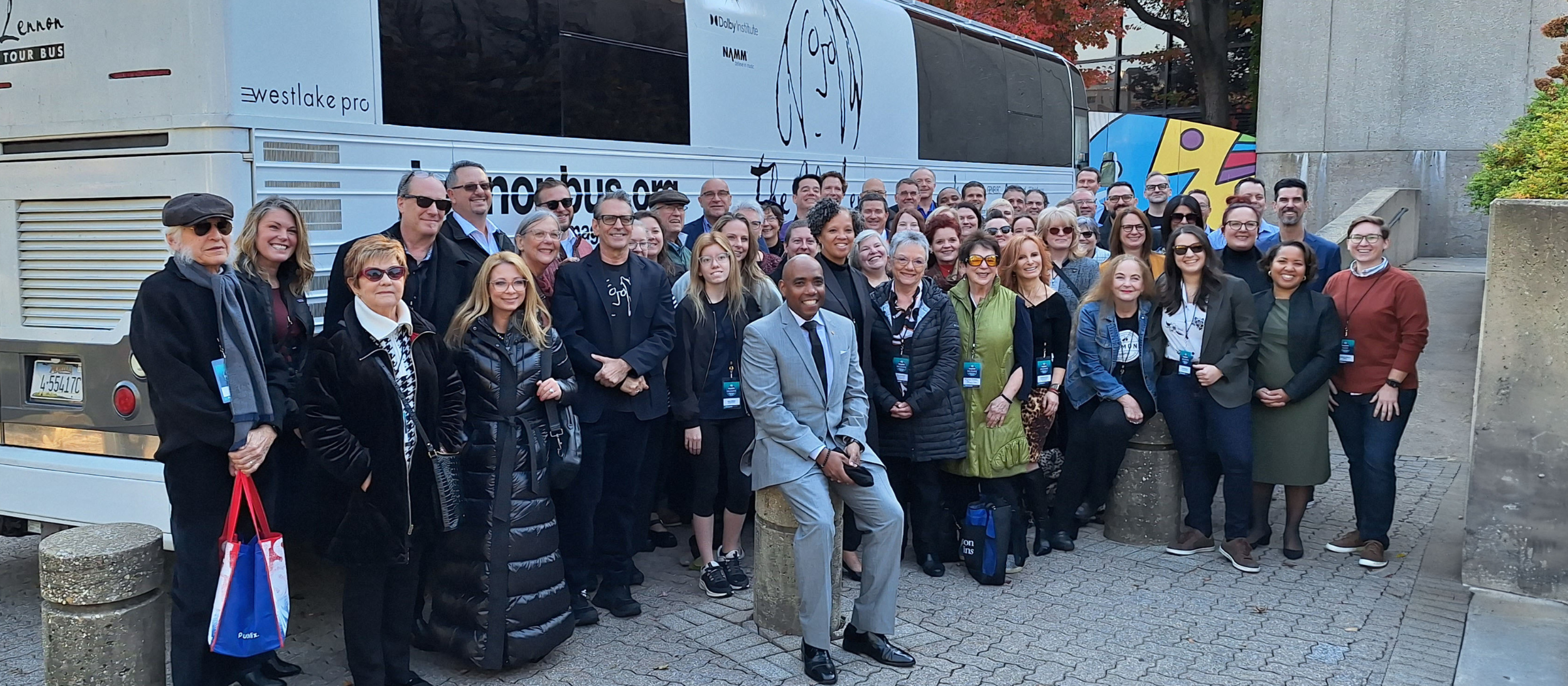 Interim College of Arts and Sciences Dean Dr. Jeffery Fleming (sitting) poses with members of the National Association of Music Merchants (NAMM) in front of the John Lennon Tour Bus.