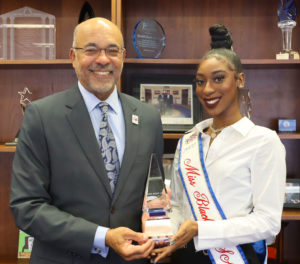 The reigning Miss Black USA, Tahira Gilyard, presents a gift to President Ronald Mason Jr.