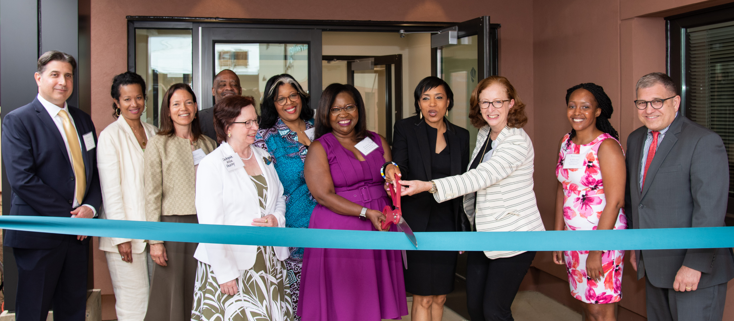 Deneen Richmond cuts the ribbon with group of people for the opening of the Behavioral Health Pavilion.