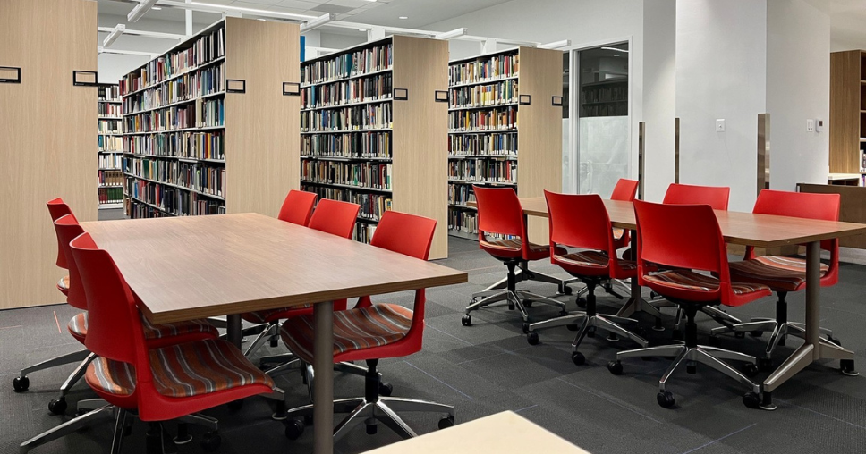 Empty tables and chairs near book shelves in the UDC Library.