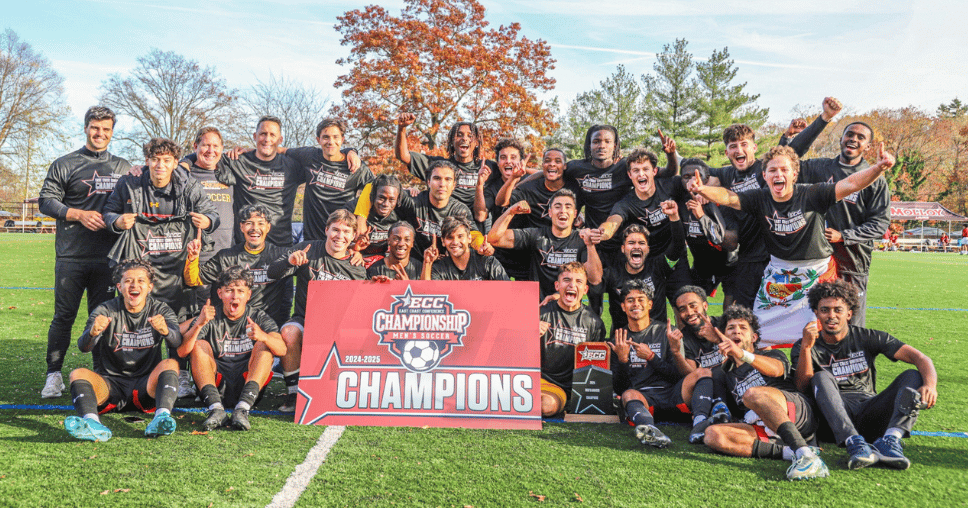 UDC Men's Soccer holding up ECC Championship Banner.