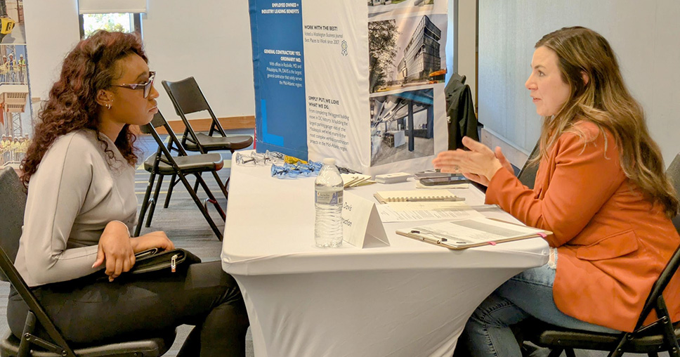 Two women sitting at a table talking.